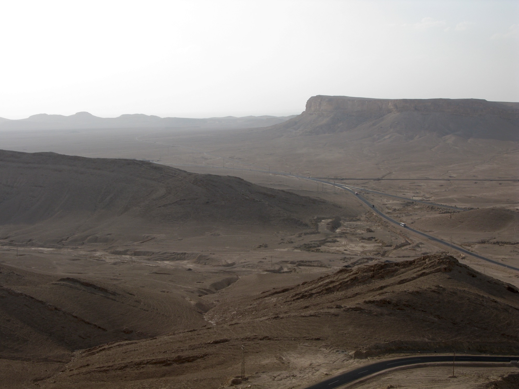 Ørkenen ved Palmyra, med nøgne bakker og en vej gennem sletten.